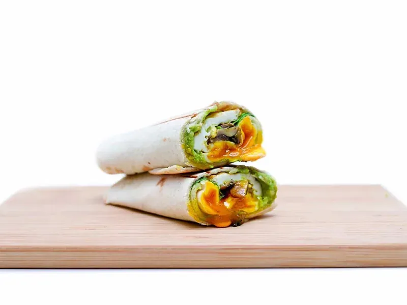 A wrap cut in half on a wooden board