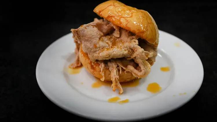 A bifana: a soft bread roll filled with thin slices of marinated pork