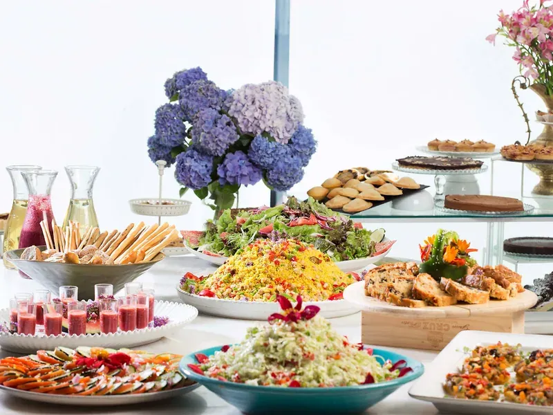 A buffet table of colourful salads, grains, juices and desserts