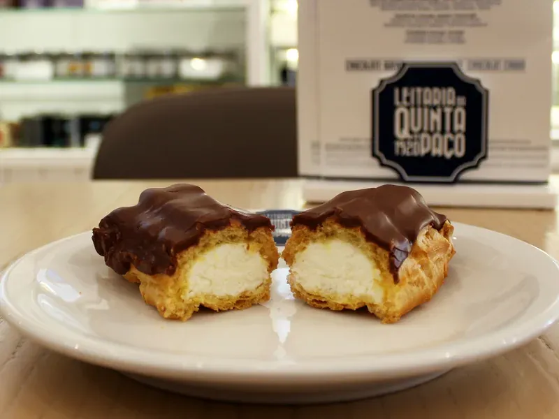 Two cream-filled éclairs with a chocolate topping on a plate
