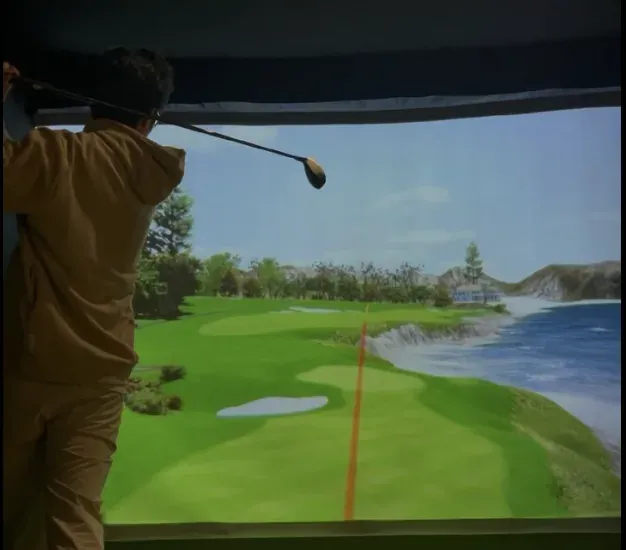 Someone swinging a club in front of a golf simulator screen