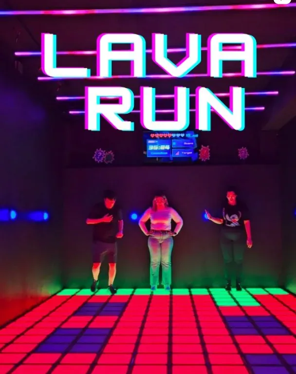 Players on a glowing tiled floor under a “Lava Run” neon sign