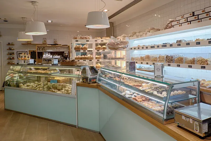 Inside a bakery with glass display counters of pastries and cakes