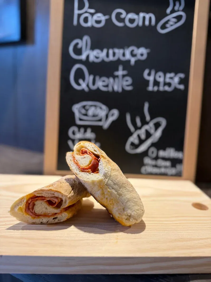 Pão com chouriço, bread baked with chorizo inside, in front of a handwritten chalkboard menu