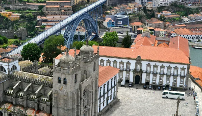 Aerial view of the cathedral and its square, with an iron bridge and the river behind