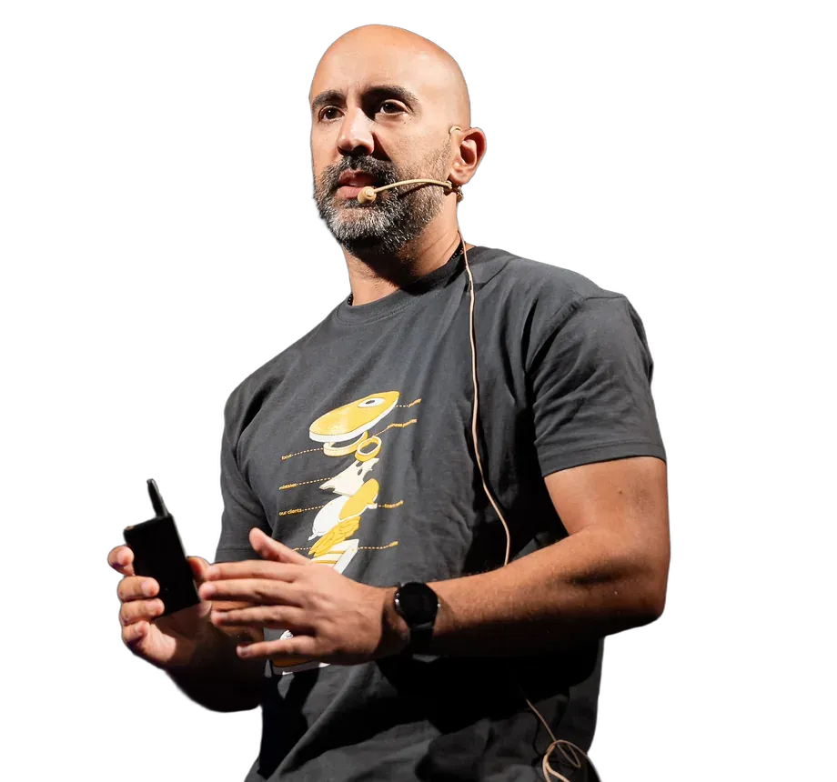 Pedro Vicente on stage mid-talk, holding a slide clicker