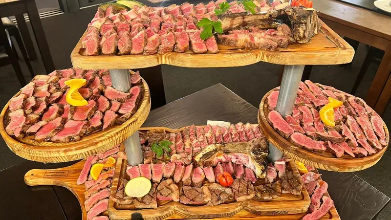 Tiered wooden boards piled with sliced rare steak