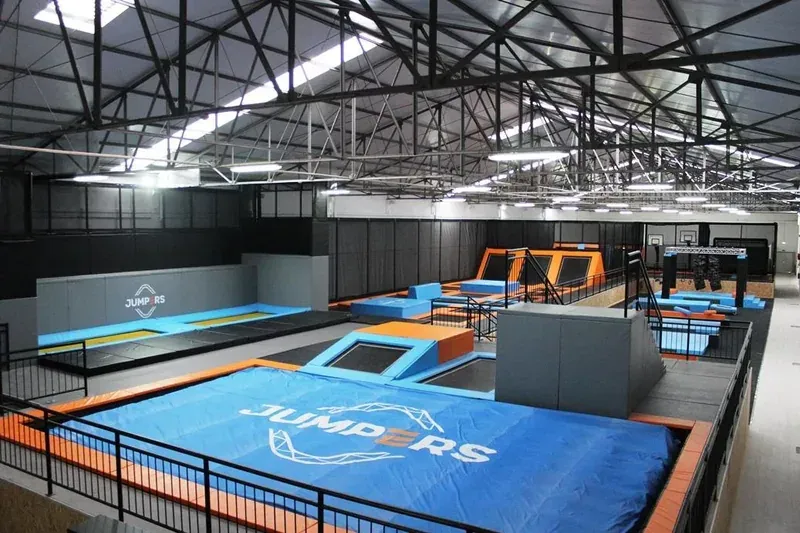 An indoor trampoline park with rows of trampolines