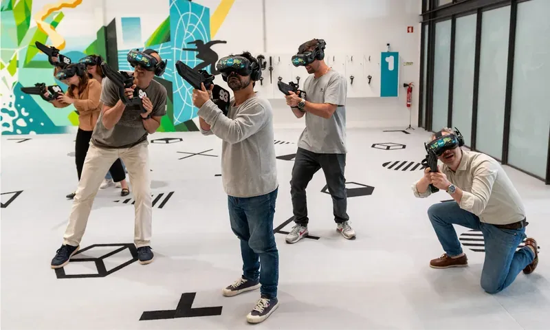 A group with VR headsets and controllers in a free-roam arena