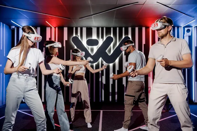 People wearing VR headsets in a neon-lit room