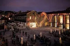 A square at night, with a light projection on the surrounding buildings